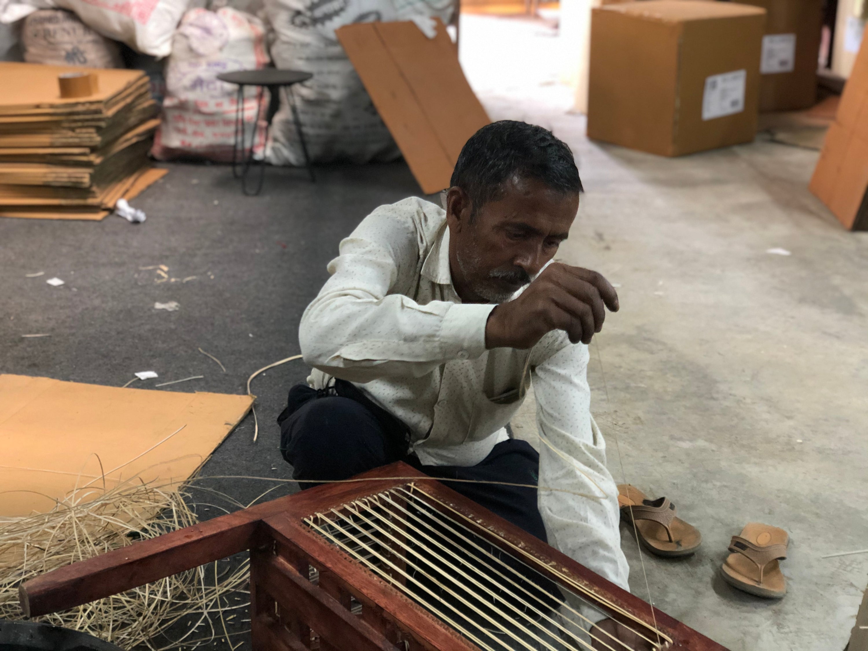 rattan artisan working on our collection of planters