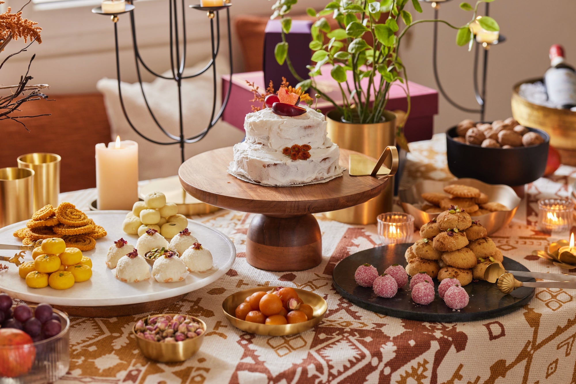 A complete festive table set with sweets, brass bowls and candles