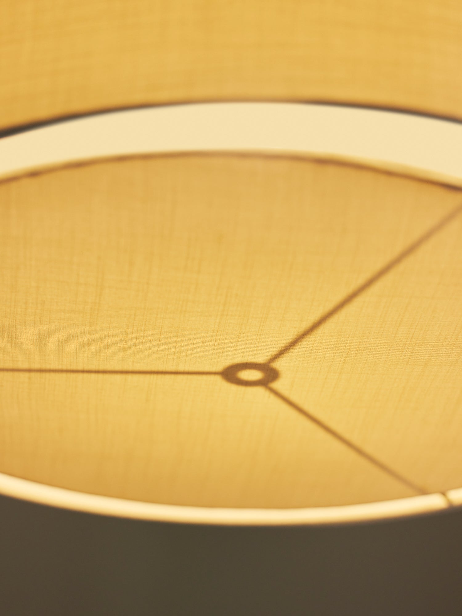 White hanging light with gold rod.