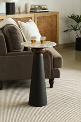 Chic modern drinks table with two drinks glasses, positioned beside a plush sofa.