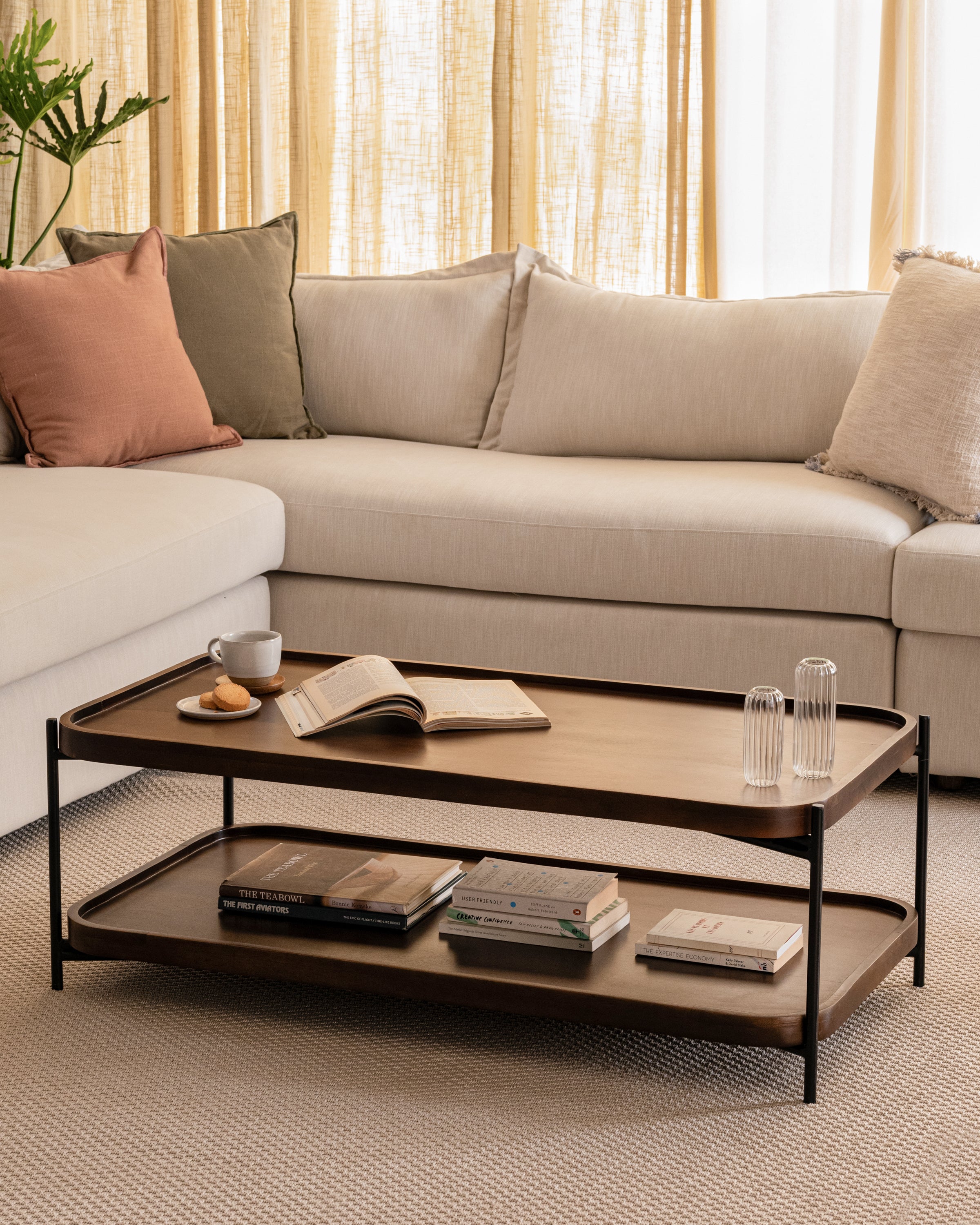Living room with L-shaped sofa and two-tier wood and metal coffee table.