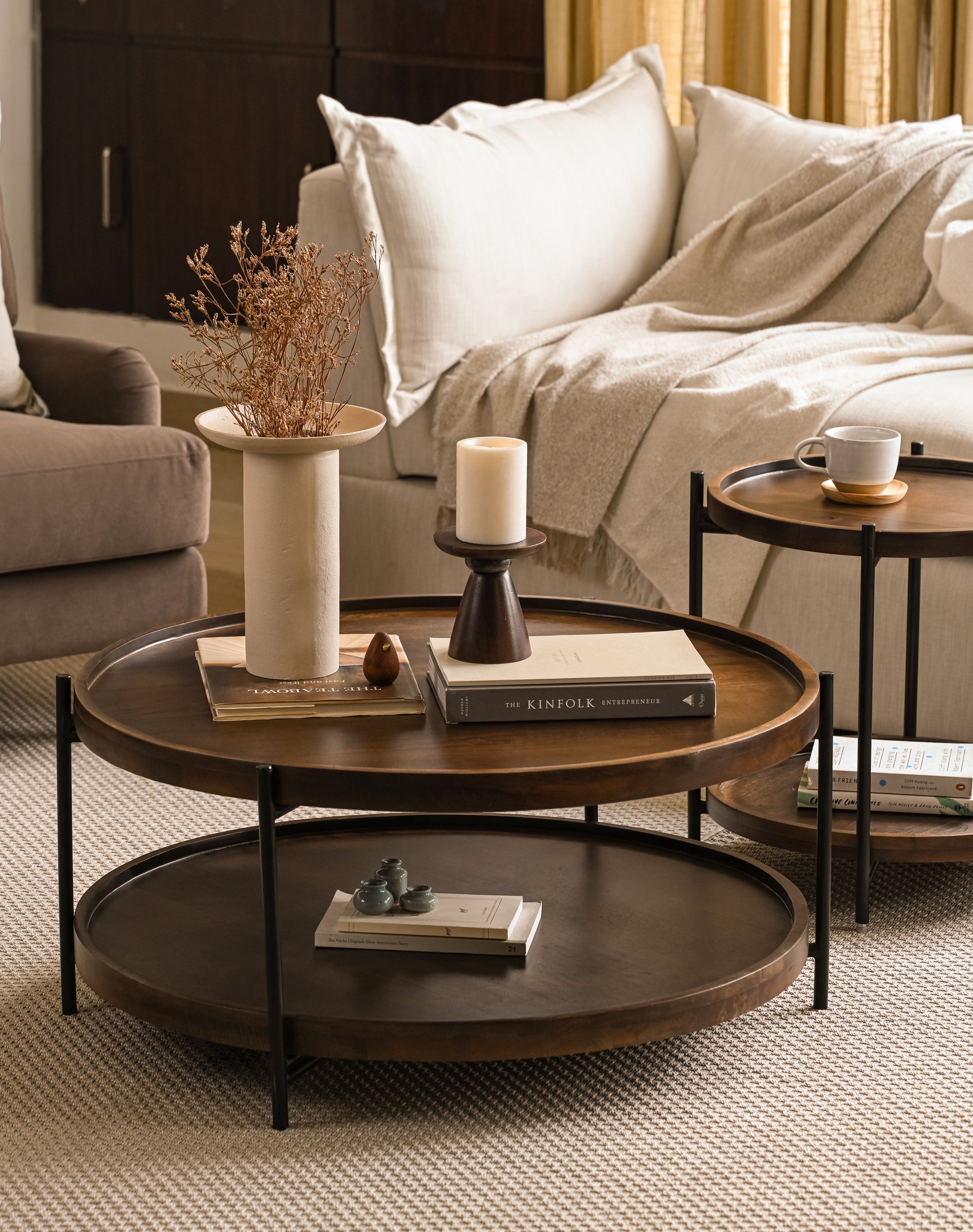 Round wooden coffee table and side table nested in a living room.