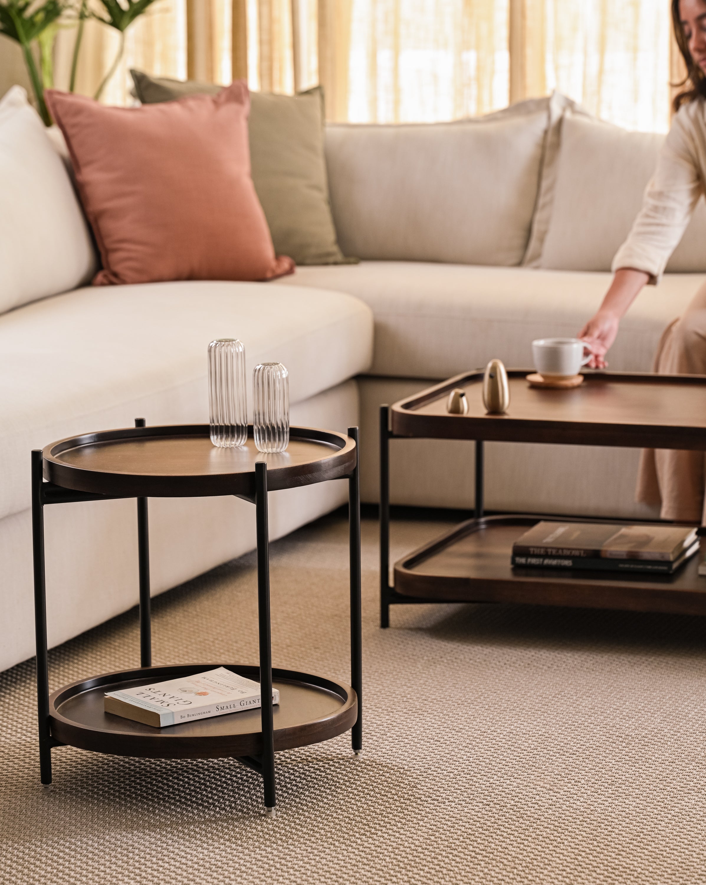 Wood and metal side and coffee tables in cozy modern living room setup.