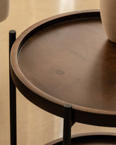 Close up of the round wooden side table with black metal frames.