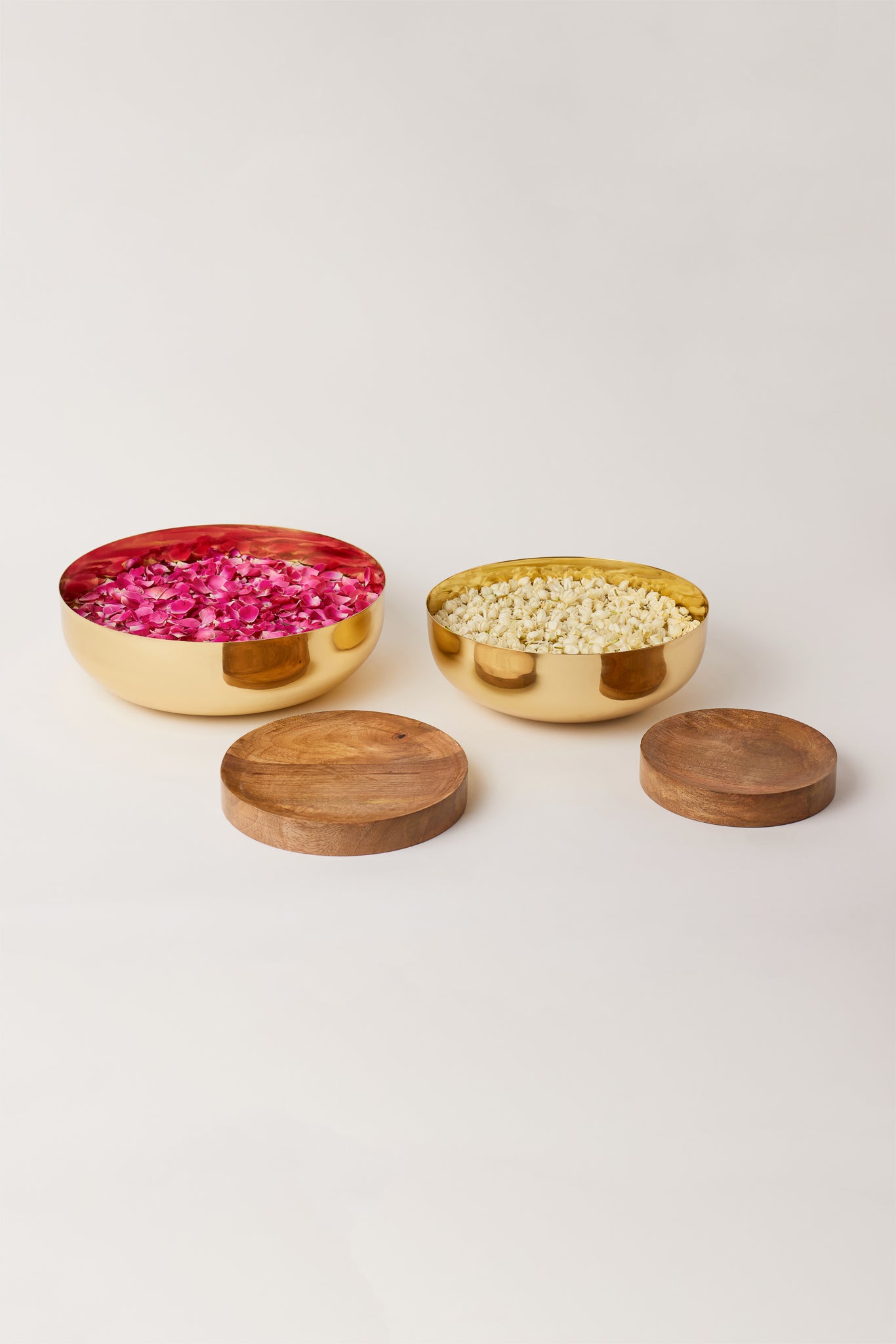 Fleck Footed Brass Urli bowl filled with flowers along with Wooden Bases