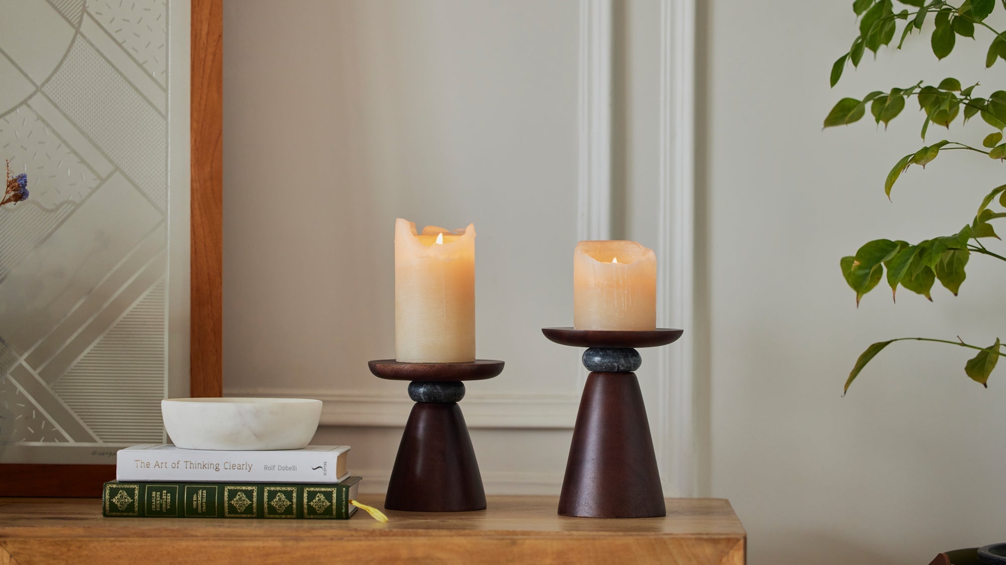 two candle holder with lit candles kept on a console