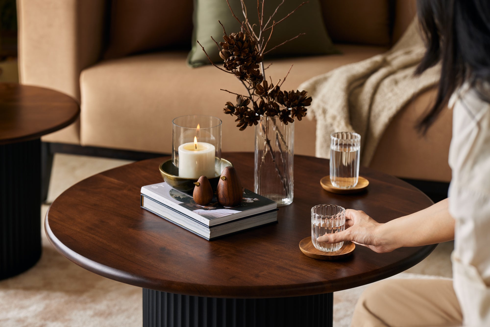 A woman placing a glass of water on the table