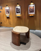 Round wooden table with a marble top in a room with wooden walls and framed pictures.