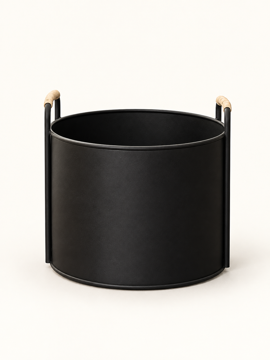 A matte black cylindrical planter or basket with two vertical side handles tipped in light natural wood, shown on a clean off-white background.