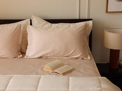 Blush Luxe Sateen Flat Sheet and Pillow with a book