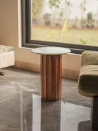 Small Side table with wooden base and marble top in a room with a window.
