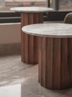 Round wooden table with a marble-like top in an indoor setting