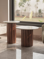 Two marble-top side tables with wooden bases in a modern interior setting.