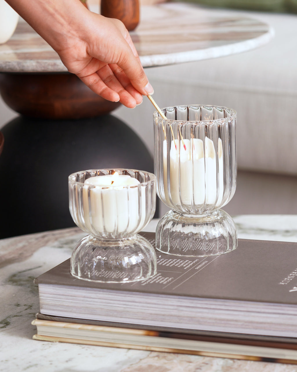 Decorative glass candle holders featuring white candles – ideal for living room or tabletop styling.