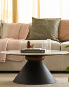 Marble coffee table with unique black pedestal base, decorated with Kinfolk book and vases.