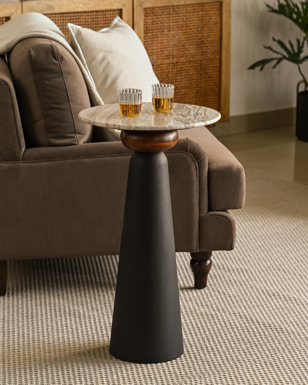 Stylish modern drinks table with marble surface and dark pedestal base in living room.