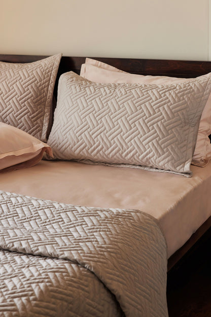 Pewter basketweave quilt and two shams made with 100% organic cotton sateen layered with blush sateen bedding