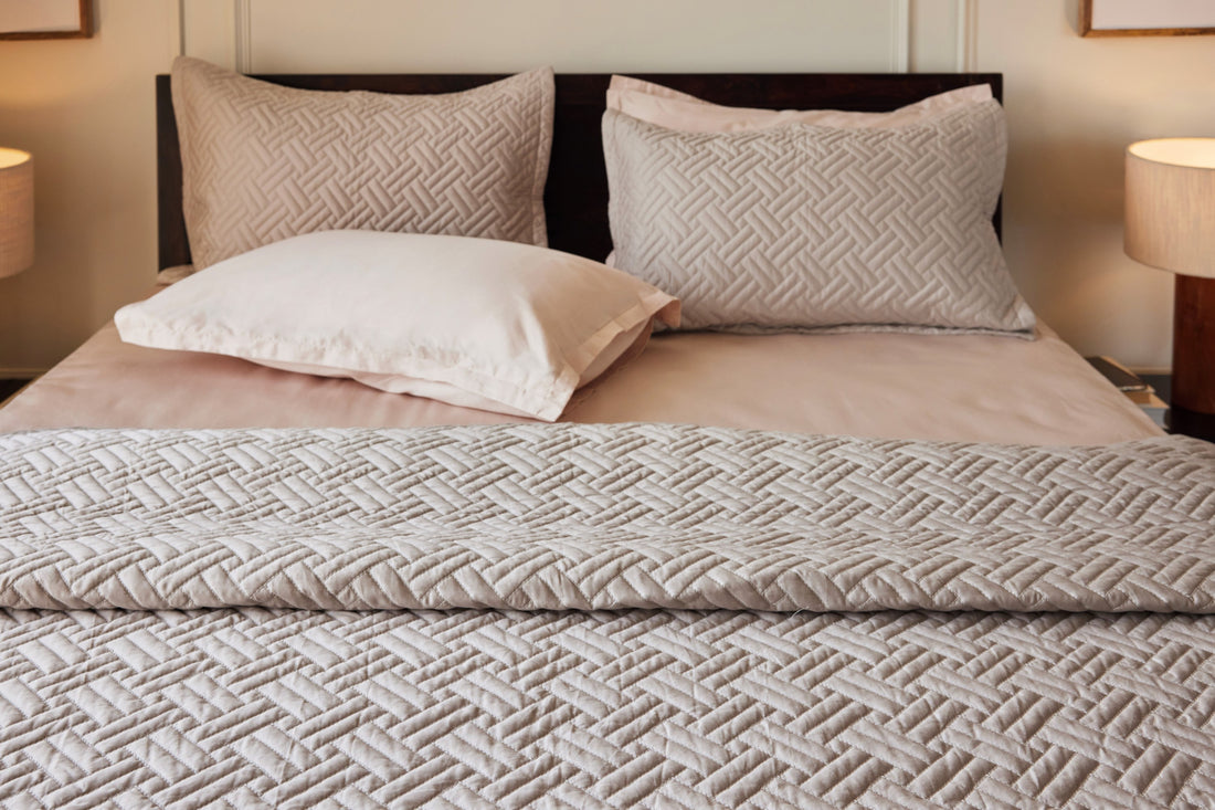 Pewter basketweave quilt and two shams layered with blush sateen bed sheet set
