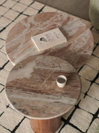 Round marble coffee table with a book and a cup on a patterned rug