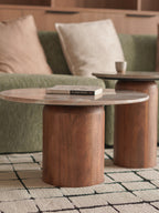 Wooden coffee table with a book on a green sofa in a living room setting