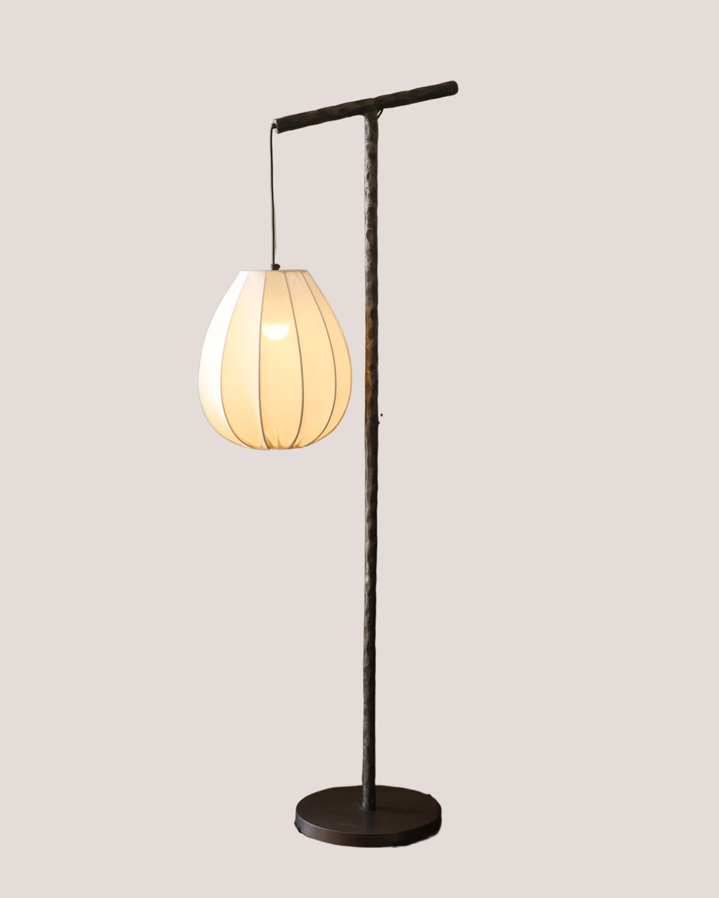 Floor lamp with white lamp shade and black carved texture stand.