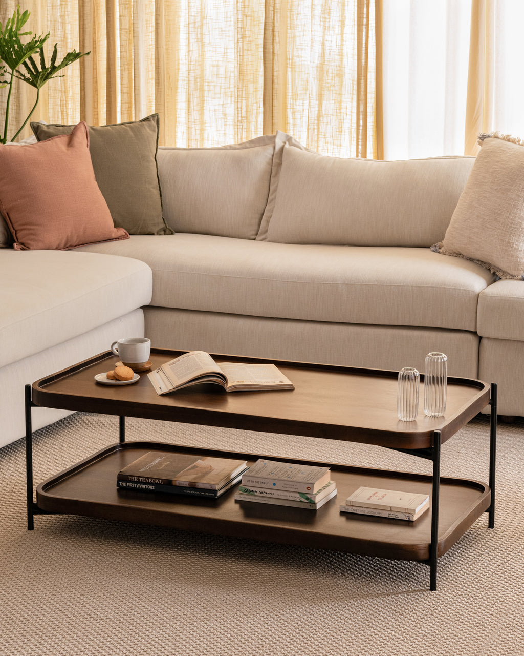 Living room with L-shaped sofa and two-tier wood and metal coffee table.