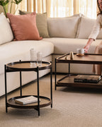 Wood and metal side and coffee tables in cozy modern living room setup.