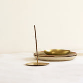 Brass Incense stick holder with two incense stick with ceramic plates in the background. Part of heirloom collection by Fleck India